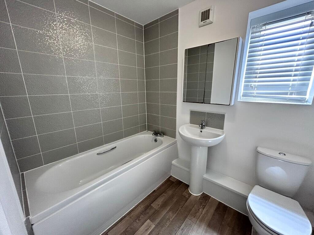 Family bathroom with bath and tiled walls